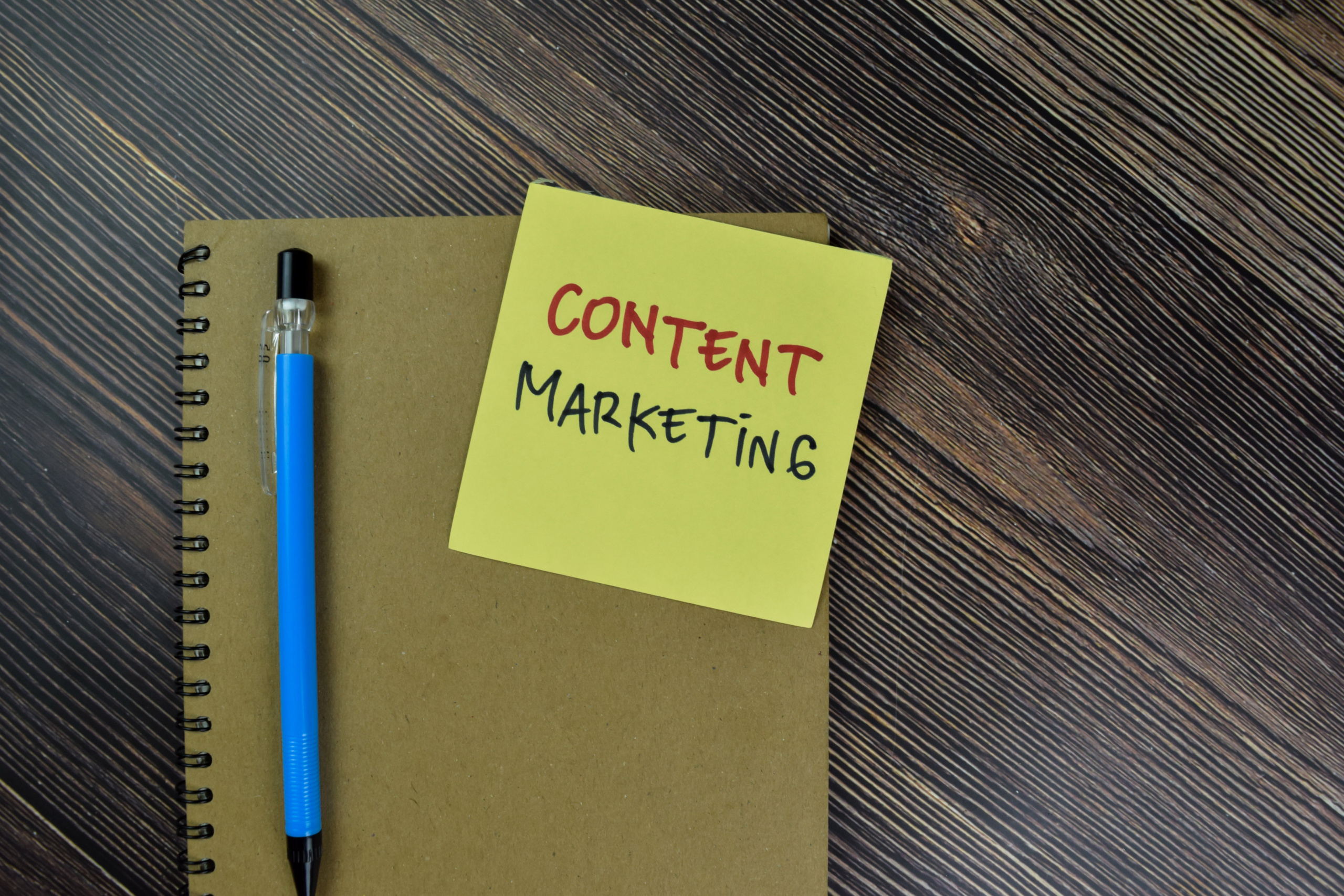 Concept of Content Marketing write on sticky notes isolated on Wooden Table.