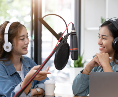 Smile two asian young woman, man radio hosts in headphones, micr