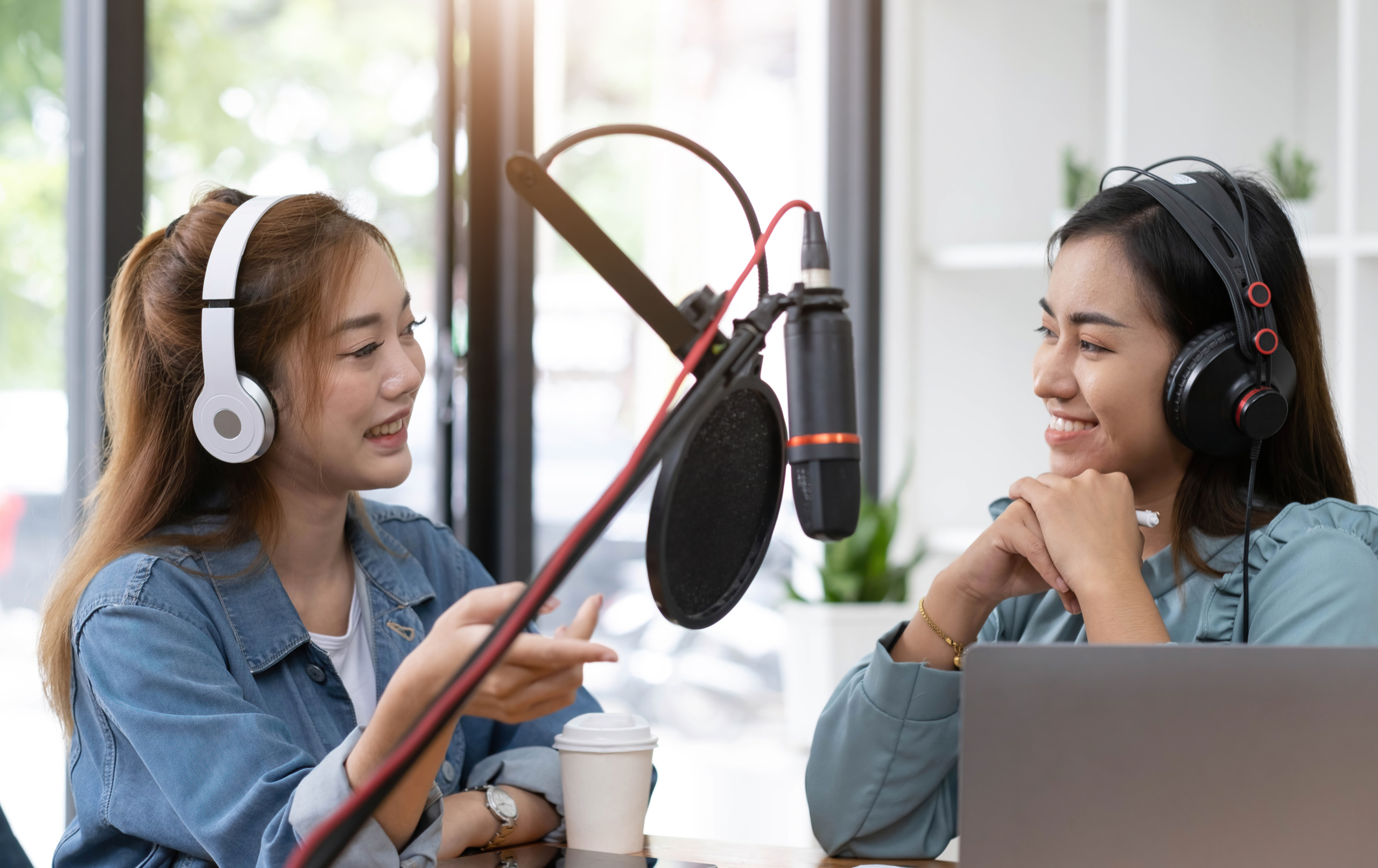 Smile two asian young woman, man radio hosts in headphones, micr